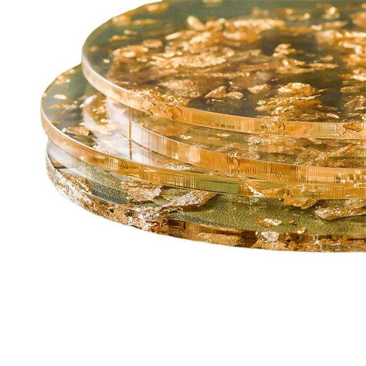 A stack of round clear glass coasters embedded with shimmering gold foil flakes, photographed on a clean white background.