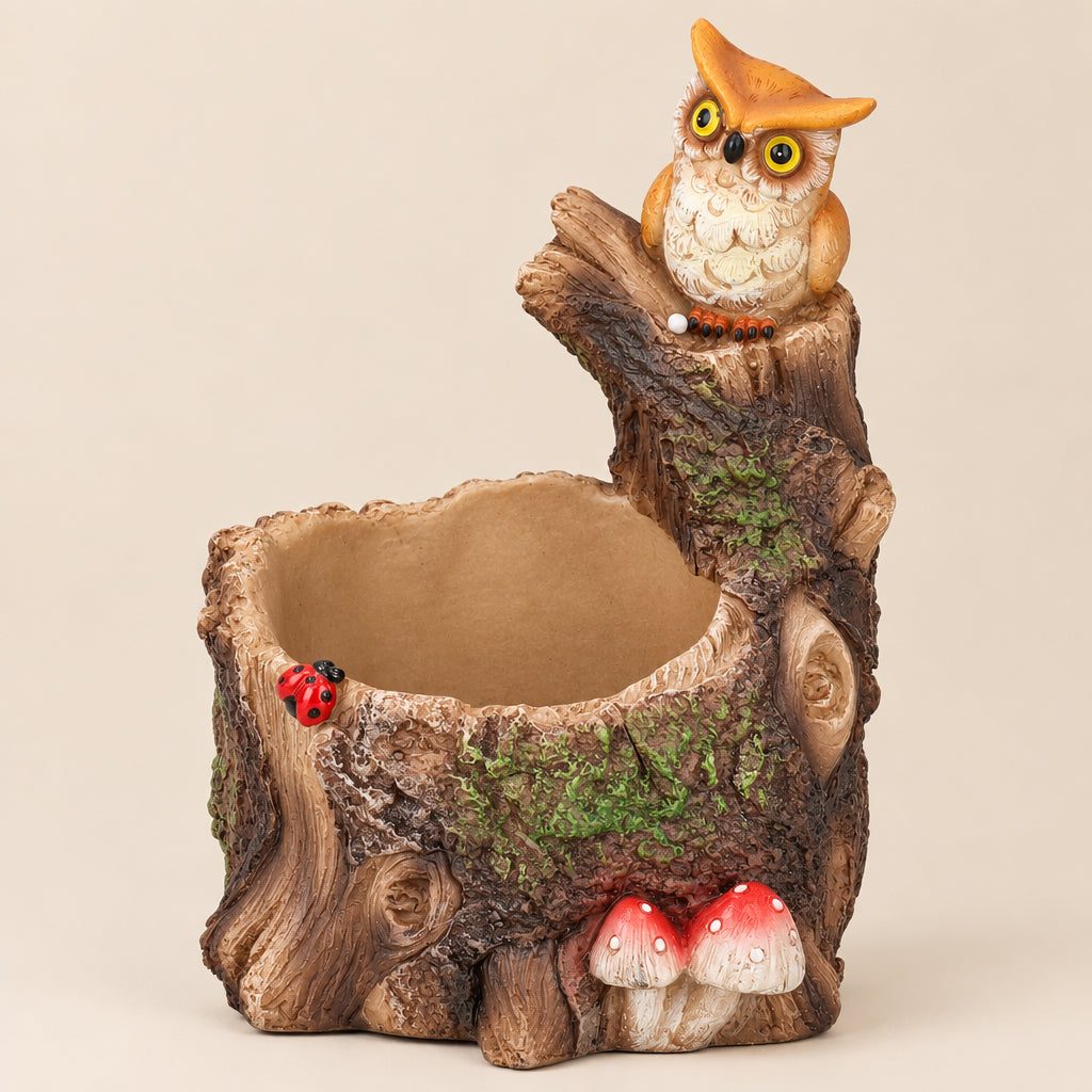 A whimsical owl garden pot shaped like a tree stump, featuring a small orange and cream owl perched on top, a hollow center for water, a tiny red ladybug detail, and red-and-white mushrooms at the base, shown on a plain white background.