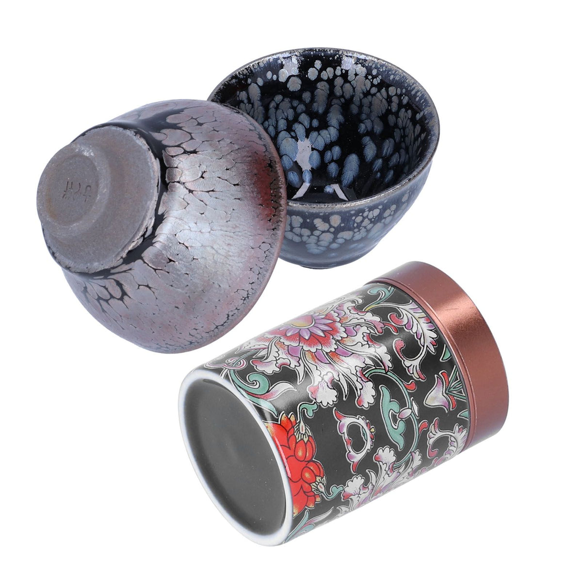 Three views of a ceramic tea cup set on a white background: one cup shown upside down revealing a crackled glaze, one cup showing the speckled interior, and one cylindrical cup with a floral pattern and copper-toned rim.