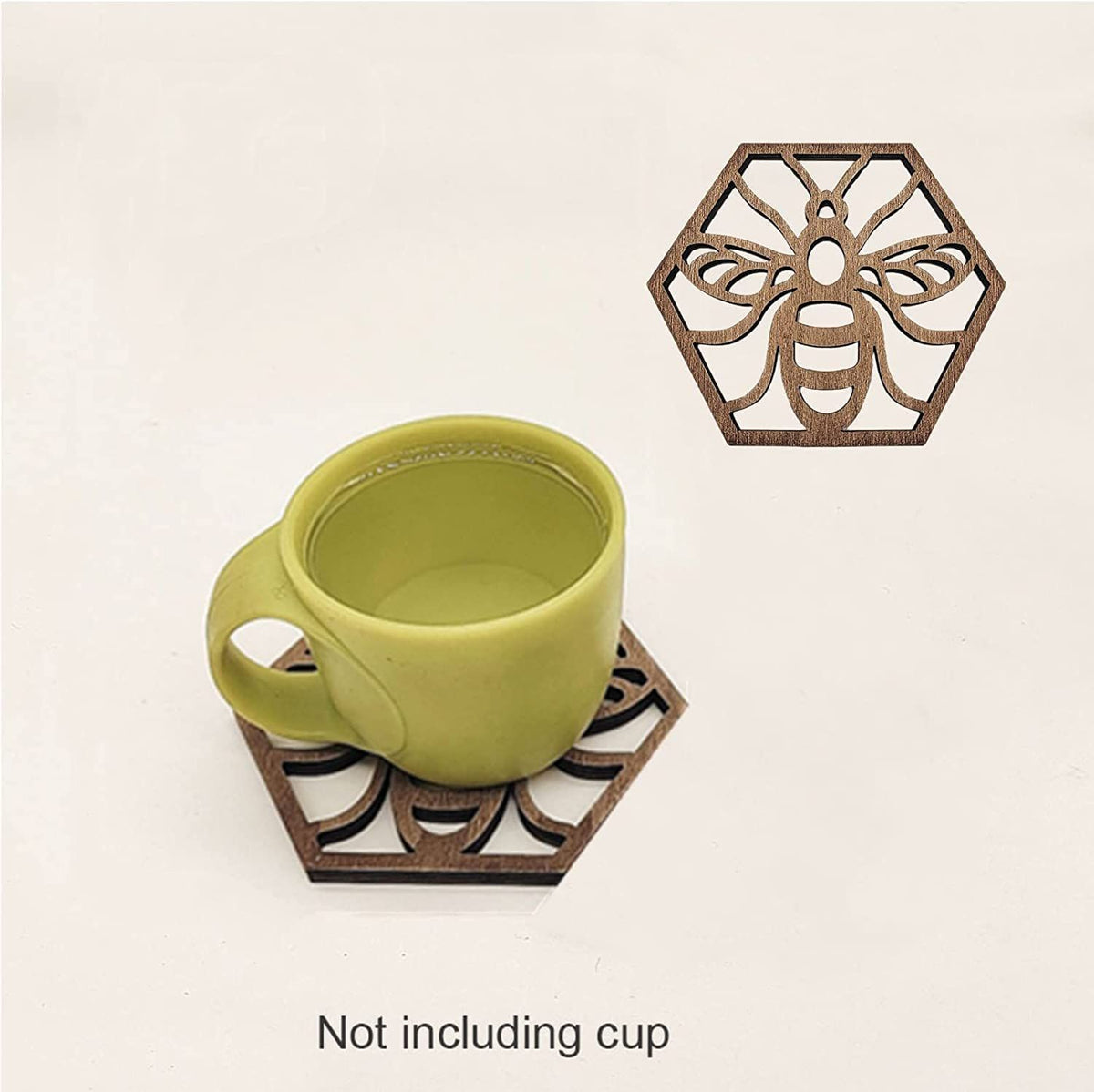 A hexagonal brown wooden bee-shaped trivet coaster shown on a light beige background, with a green ceramic cup placed on top. Text at the bottom reads 'Not including cup'.