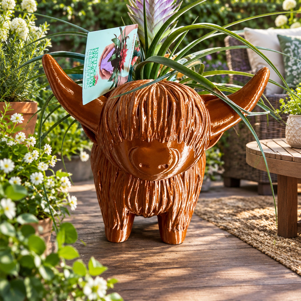 Brown cow-shaped planter with a plant on a marble surface