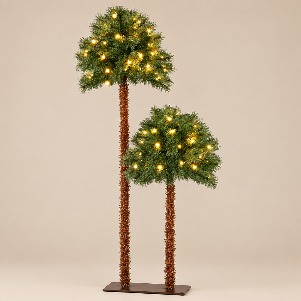 Two artificial palm tree decorations with green pine-like crowns, warm white string lights, and brown textured trunks, displayed on a plain beige studio background.